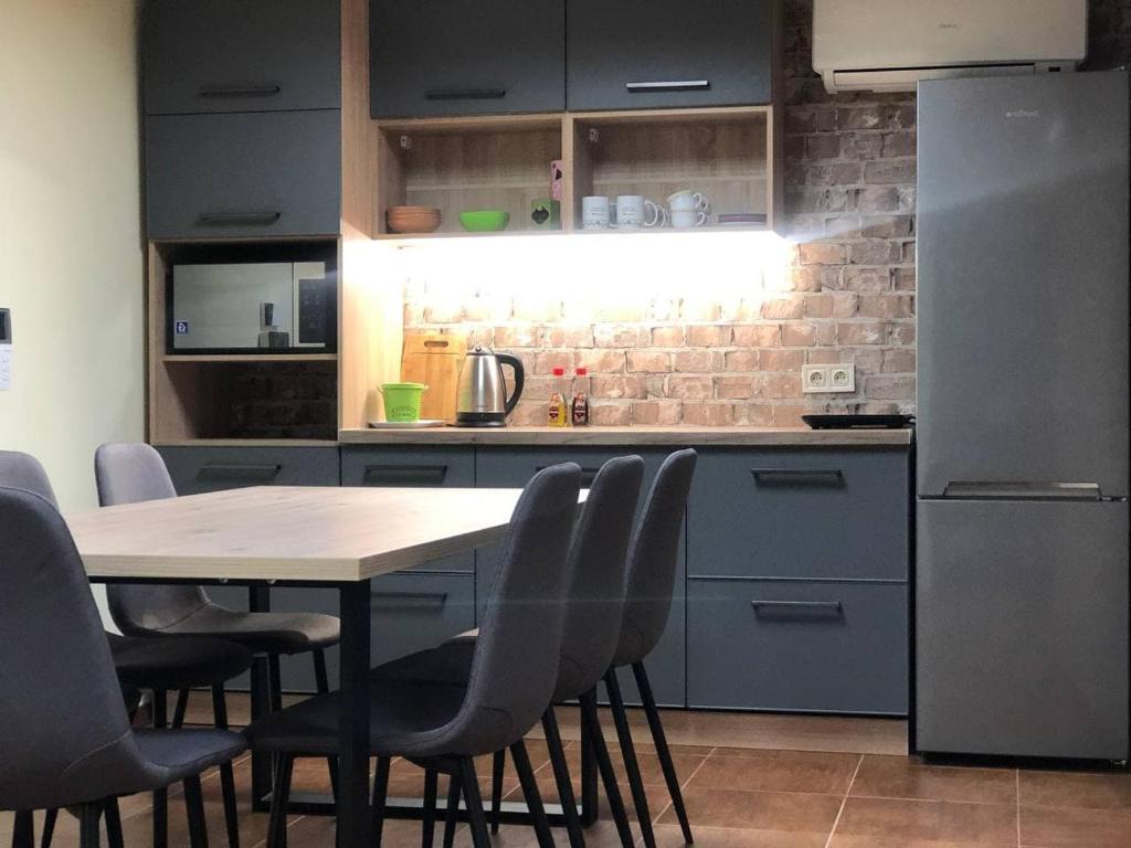 a kitchen with a table and chairs and a refrigerator at Хостел Lime in Dnipro