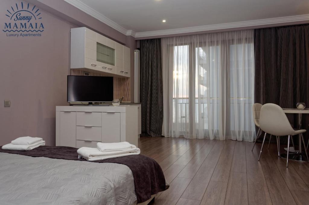 1 dormitorio con cama, mesa y TV en Ady's Studio en Mamaia