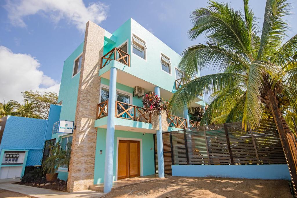 una casa colorida con palmeras delante en Casa Menta en Puerto Escondido