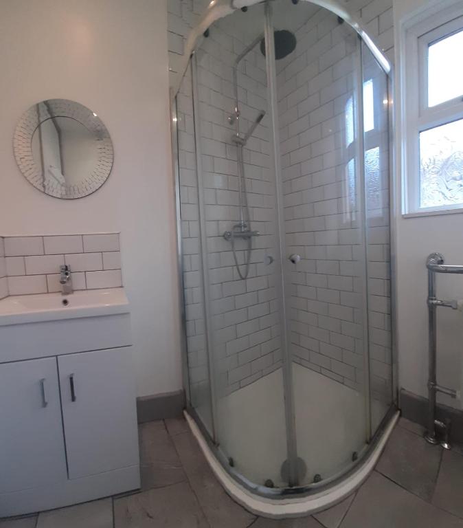 a bathroom with a shower with a sink and a mirror at Home from Home Stay Margate in Margate
