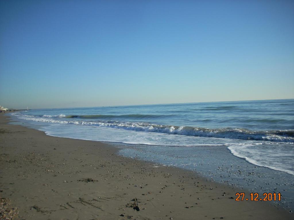 einen Strand mit Wellen aus dem Meer in der Unterkunft Aroma Di Mare in Lido di Ostia