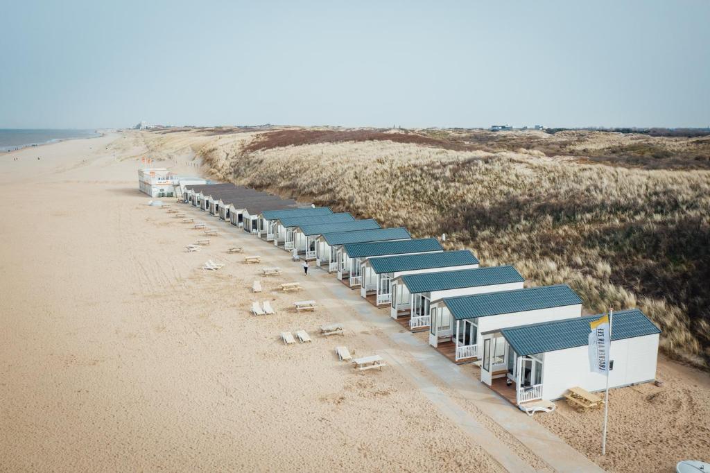 uma fila de abrigos numa praia arenosa em Logeren aan Zee em Katwijk aan Zee