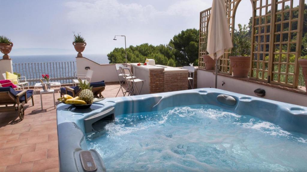 a hot tub on a patio with a view of the ocean at Villa Priscilla in Taormina