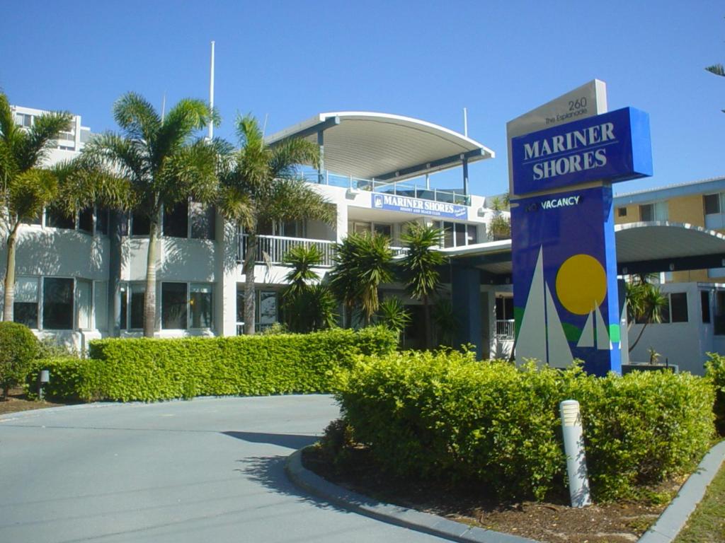 a sign in front of a building with palm trees at Mariner Shores Club in Gold Coast
