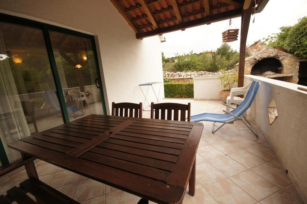 Une table et des chaises en bois sont disponibles sur la terrasse. dans l'établissement Guesthouse Murter 125, à Murter