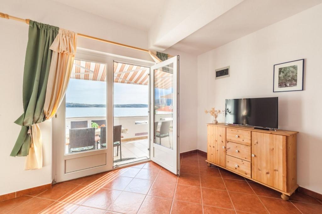 salon z telewizorem i przesuwnymi szklanymi drzwiami w obiekcie Apartment in Kustici with Seaview, Balcony, Air condition, WIFI (3589-1) w mieście Kustići