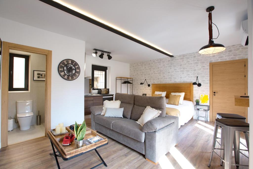 een woonkamer met een bank en een bed bij Cuencaloft Apartamentos el Nazareno in Cuenca