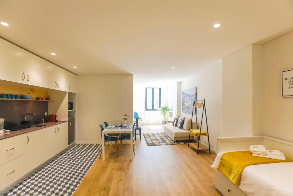 sypialnia z łóżkiem oraz kuchnia ze stołem w obiekcie Oliveira Apartment`s w Porto