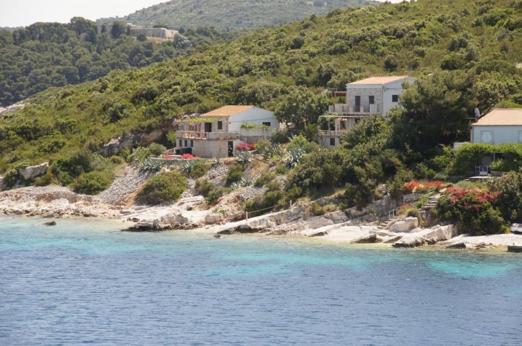 a group of houses on a hill next to the water at Holiday Home (139-3) in Vis