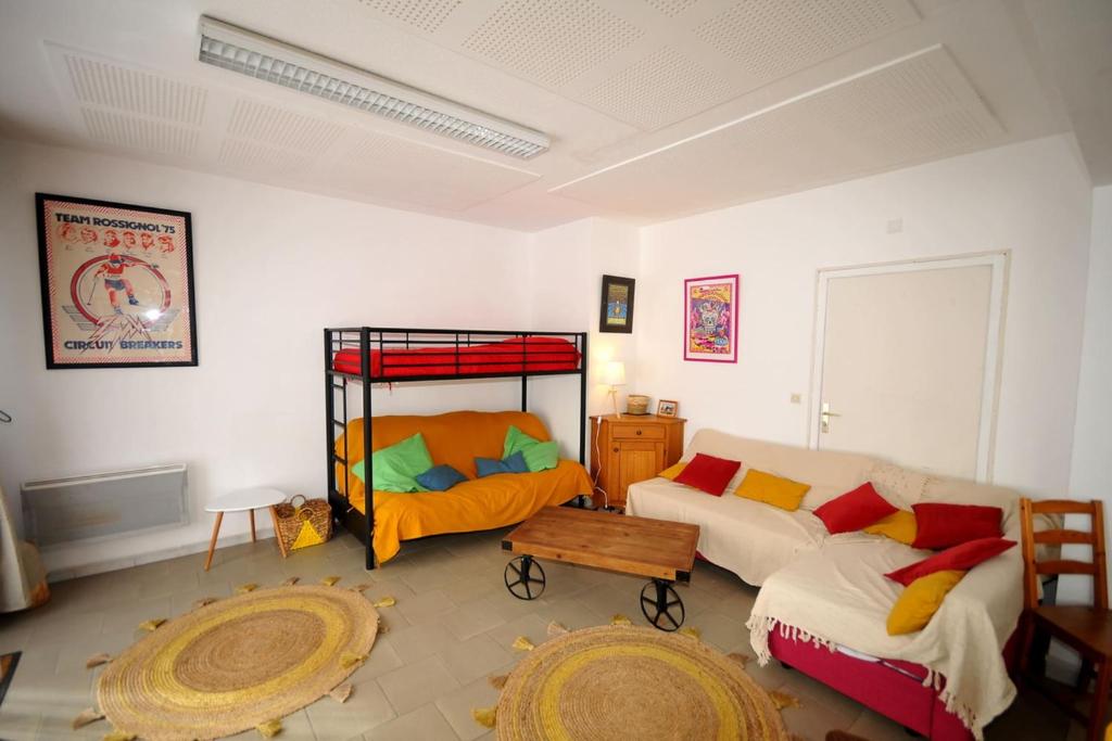 a living room with a couch and a bunk bed at Gîte le Rocher - Apartment on the ground floor for 8 people in La Grave