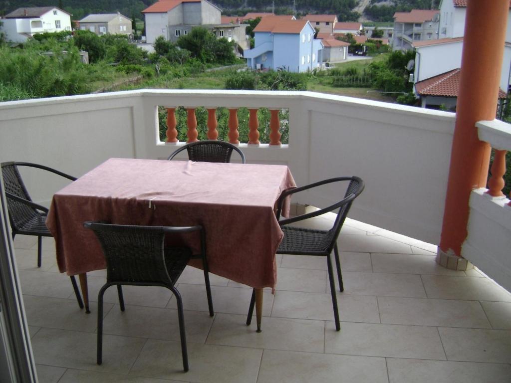 a table and chairs on a balcony with a view at Guesthouse Lopar (568) in Lopar