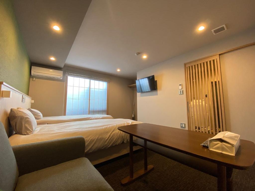 um quarto de hotel com duas camas e uma mesa em Gion Shirakawa - Vacation STAY 24774v em Quioto