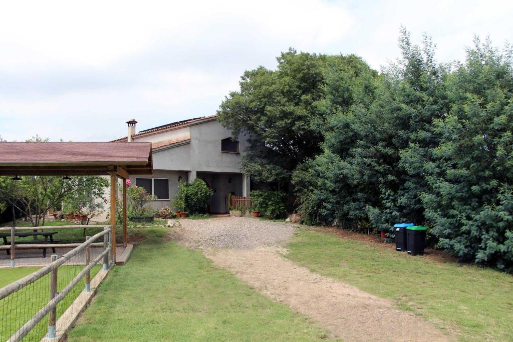 une maison avec une clôture et un chemin de terre dans l'établissement Mas Blavis, à Riudarenes