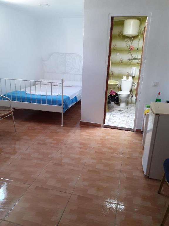 ein Schlafzimmer mit einem Bett und ein Badezimmer mit einem WC in der Unterkunft Barato habitation ( chip rooms) in Los Cristianos