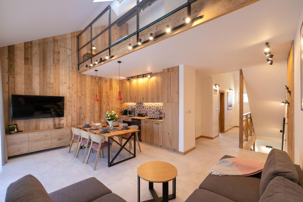 een open woonkamer met een tafel en een bar bij Apartament Pod Stokiem E2 z garażem i dwoma łazienkami - Dream Apart in Szczyrk