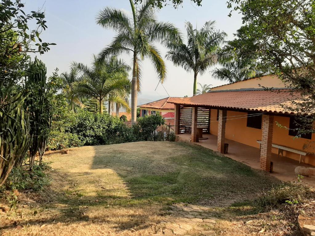 une maison avec une cour plantée de palmiers devant elle dans l'établissement Sitio Carvalho da Serra, à Caeté