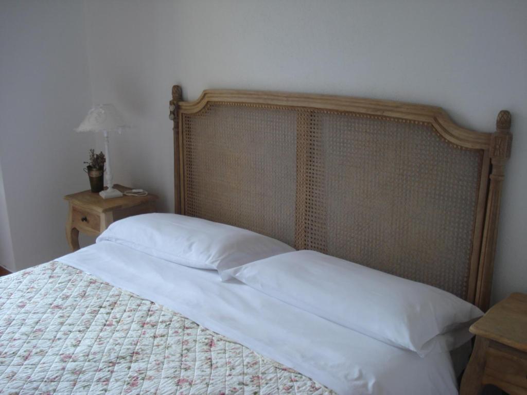 a bedroom with a bed with a wooden headboard at Il Giardino di Julia B&B in Tortora