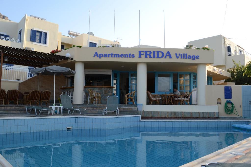 um hotel com piscina em frente a um edifício em Frida Village em Hersonissos