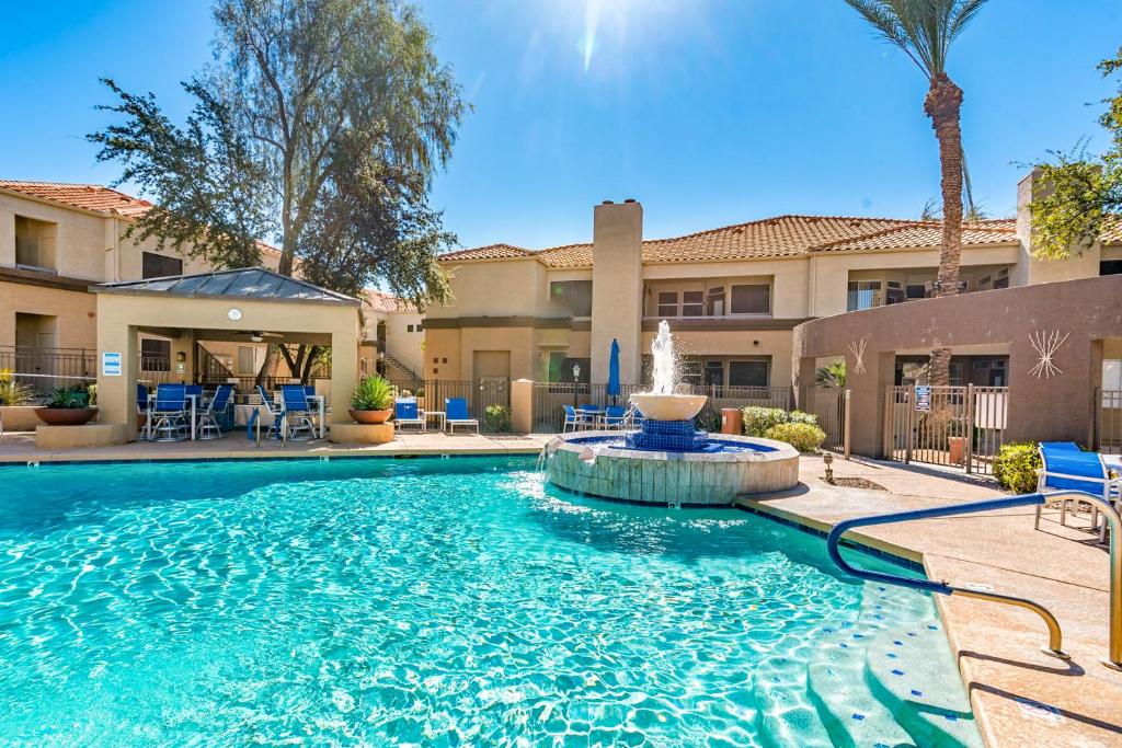 uma piscina com uma fonte em frente a um edifício em Sahuaro Condos em Scottsdale