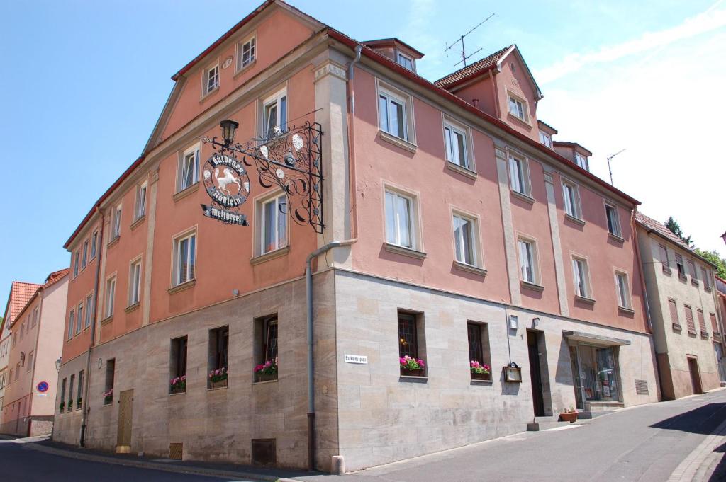 een groot gebouw met een klok aan de zijkant bij Gasthaus Zum güldenen Rößlein in Homburg