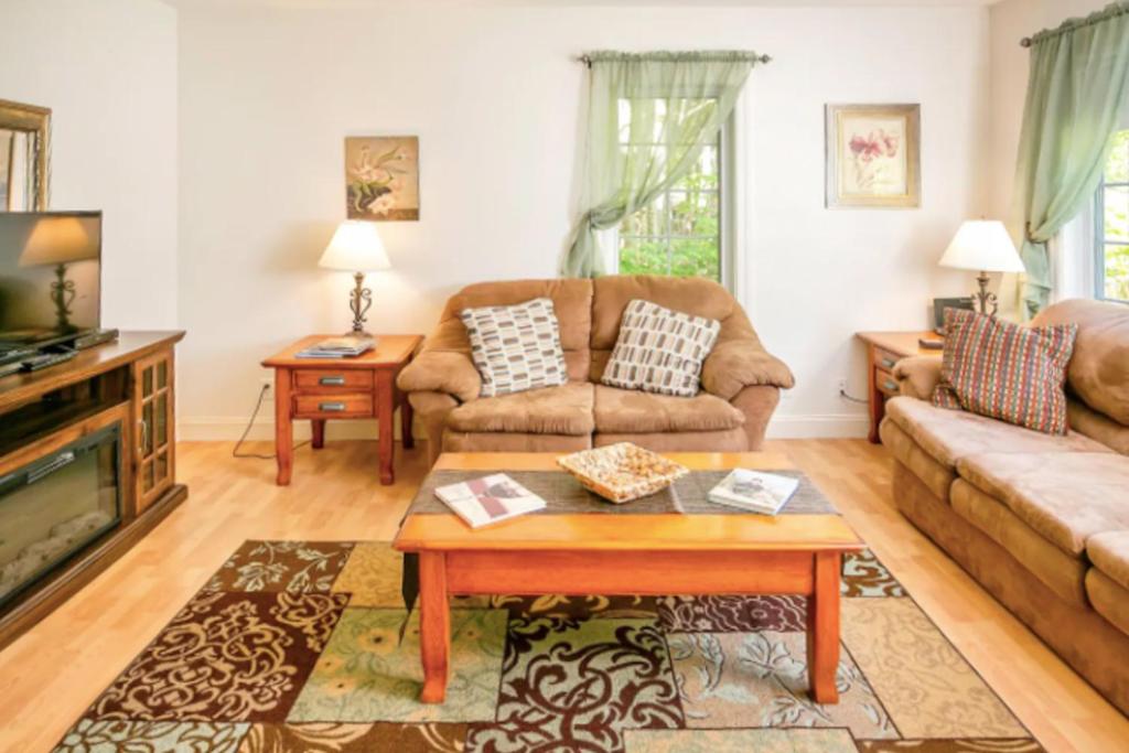 un salon avec un canapé et une table dans l'établissement Dogwood Cottage, à Bar Harbor