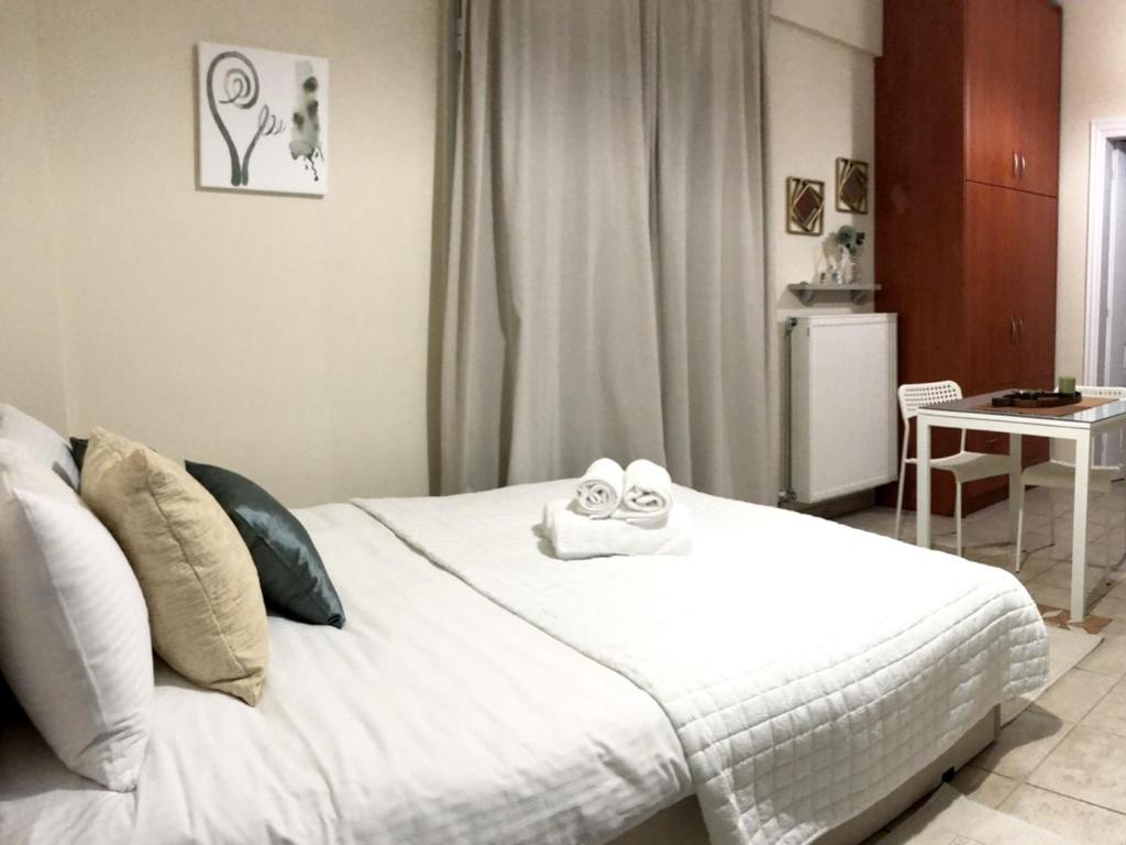 a bedroom with a white bed with towels on it at Stergios_Apartments 03 in Kozani