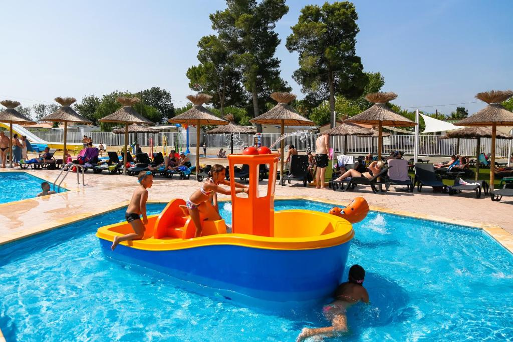 a group of people in a pool at a resort at Mobile home De Luxe St Cyprien in Saint-Cyprien
