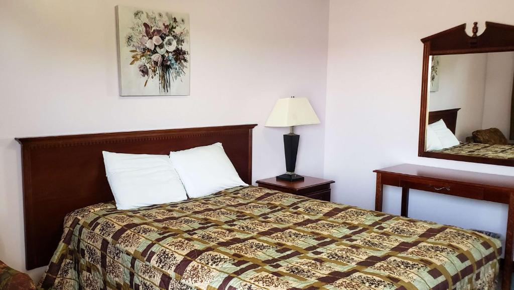 a hotel room with a bed and a mirror at Windmill Inn Lynden in Lynden