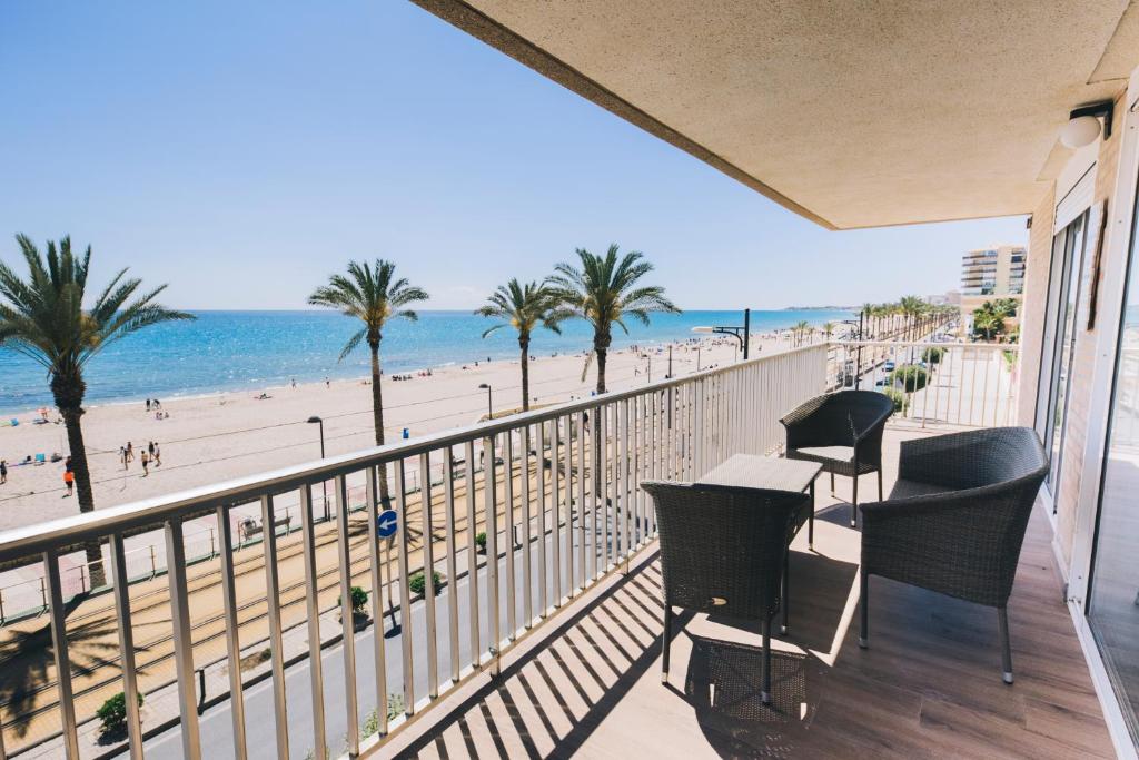 a balcony with chairs and a view of the beach at GLP RASPEIG DREAMSEA in El Campello