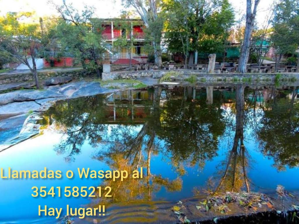 un reflejo de un puente en un cuerpo de agua en Hosteria Sans Souci in 