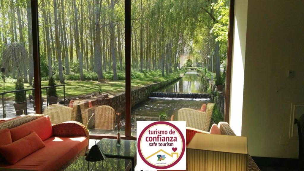 a room with a window with a view of a river at Hotel El Molino de Salinas in Salinas de Pisuerga