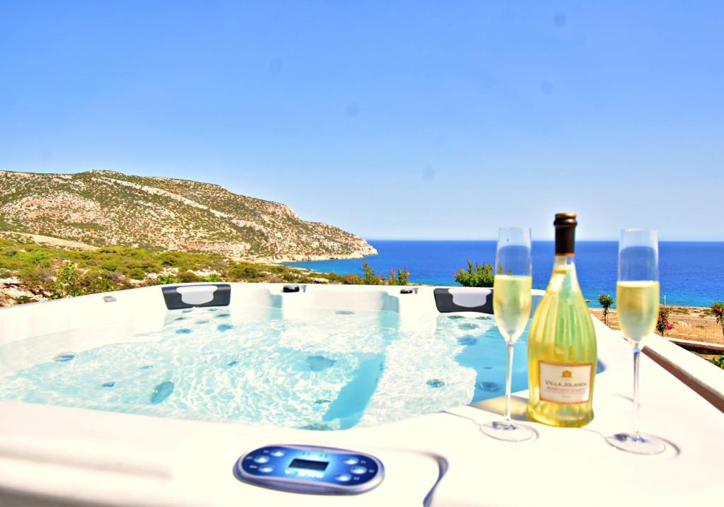 a hot tub with two bottles of wine and glasses at Ardani paradise view villa with jacuzzi in Amoopi