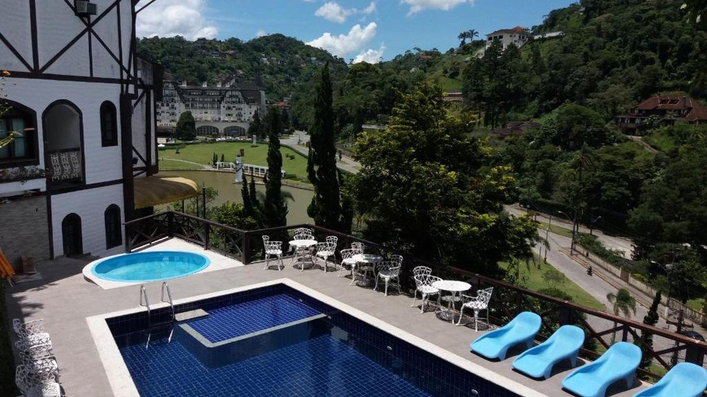 a view of a swimming pool and a house at Gallardin Palace Hotel in Petrópolis