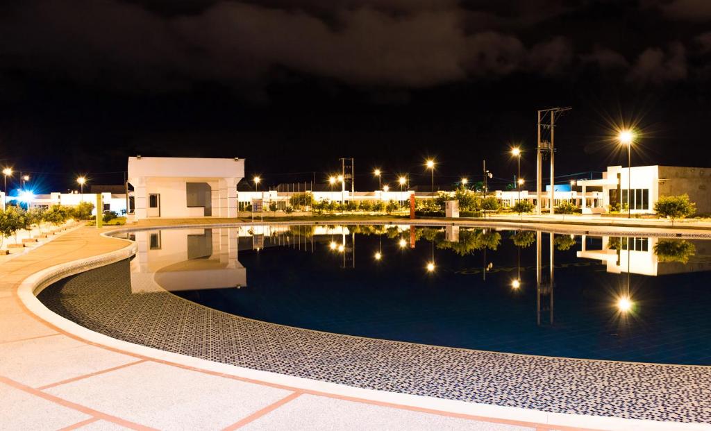 a swimming pool at night with buildings and lights at Casa Vacacional Flandes in Flandes