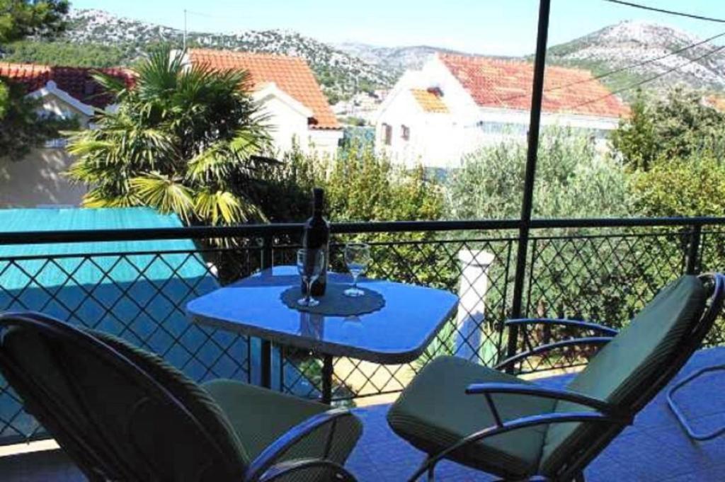 a bottle of wine sitting on a table on a balcony at Holiday home Villa Linda - big terraces in Seget Vranjica