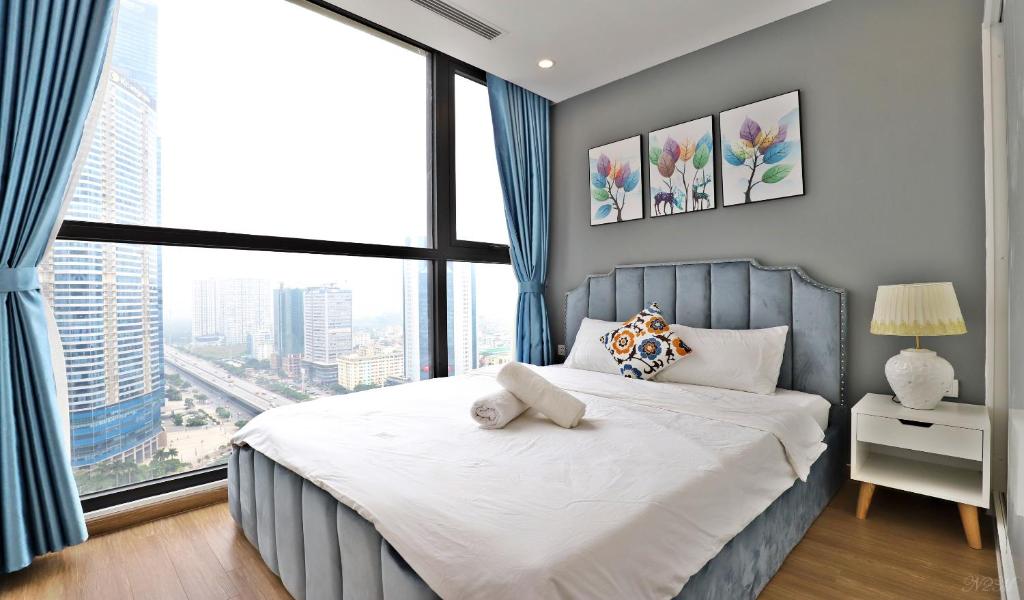 a bedroom with a bed and a large window at Vinhomes Skylake Hanoi - CitiHome in Hanoi