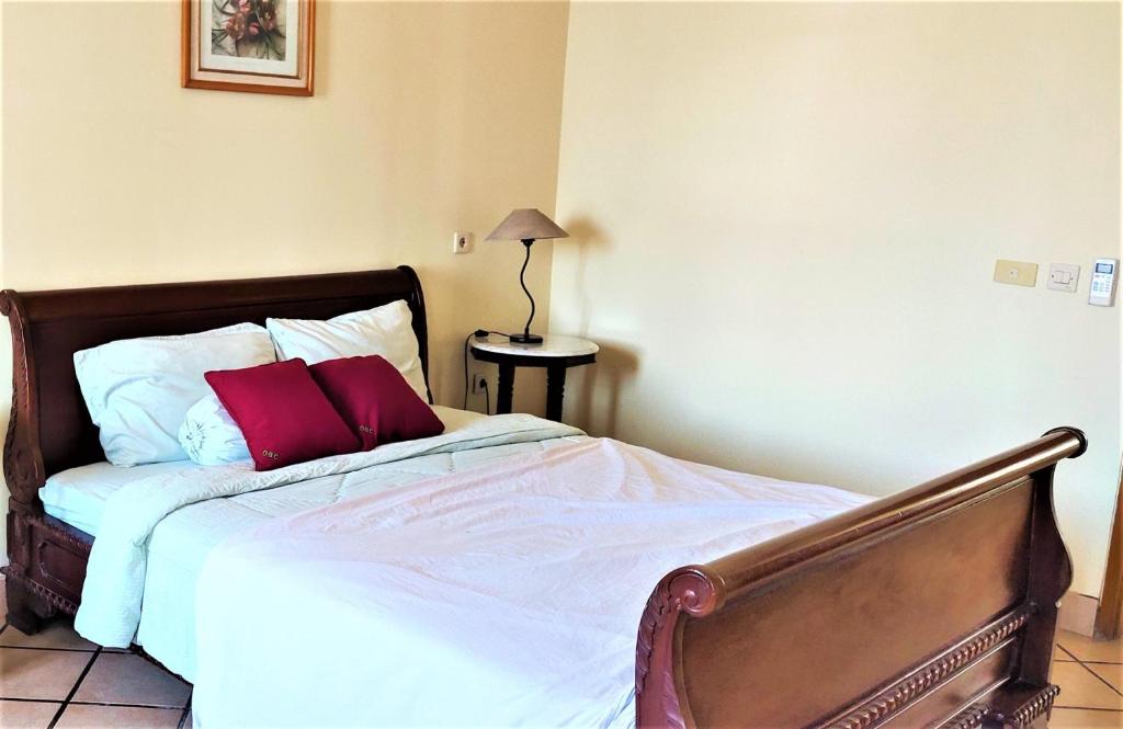 um quarto com uma cama com duas almofadas vermelhas em OBC Villa em Bandung