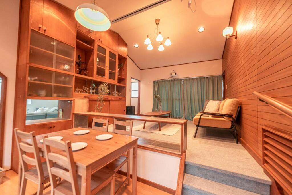 a dining room with a wooden table and chairs at シャローム伊豆高原 in Futo