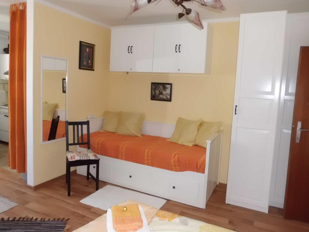 a bedroom with a bed with an orange blanket at Apartma mit Seeblick in Sankt Gilgen