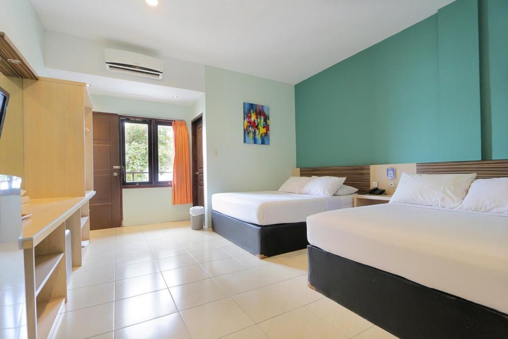 Llit o llits en una habitació de Sun In Pangandaran Hotel