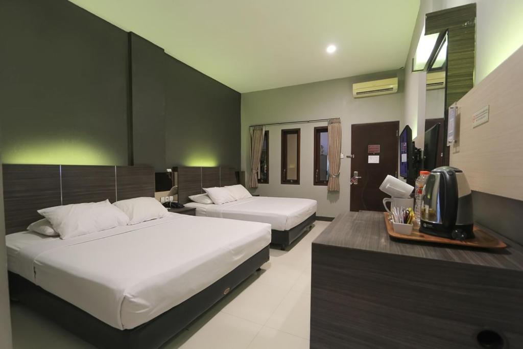 Llit o llits en una habitació de Sun In Pangandaran Hotel