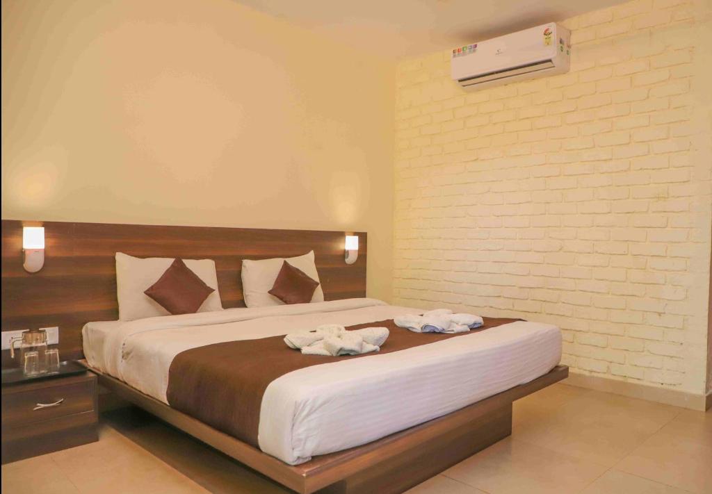 1 dormitorio con 1 cama grande y toallas. en Hotel on the Rocks, en Mahabaleshwar