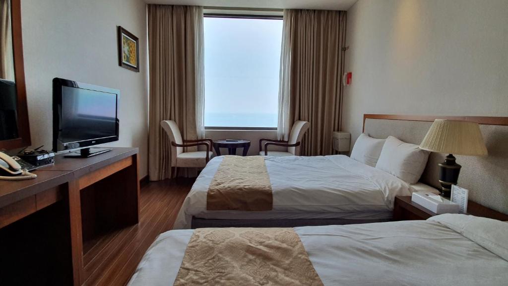 Postel nebo postele na pokoji v ubytování Gyungpo Beach Hotel