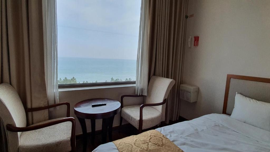 Postel nebo postele na pokoji v ubytování Gyungpo Beach Hotel