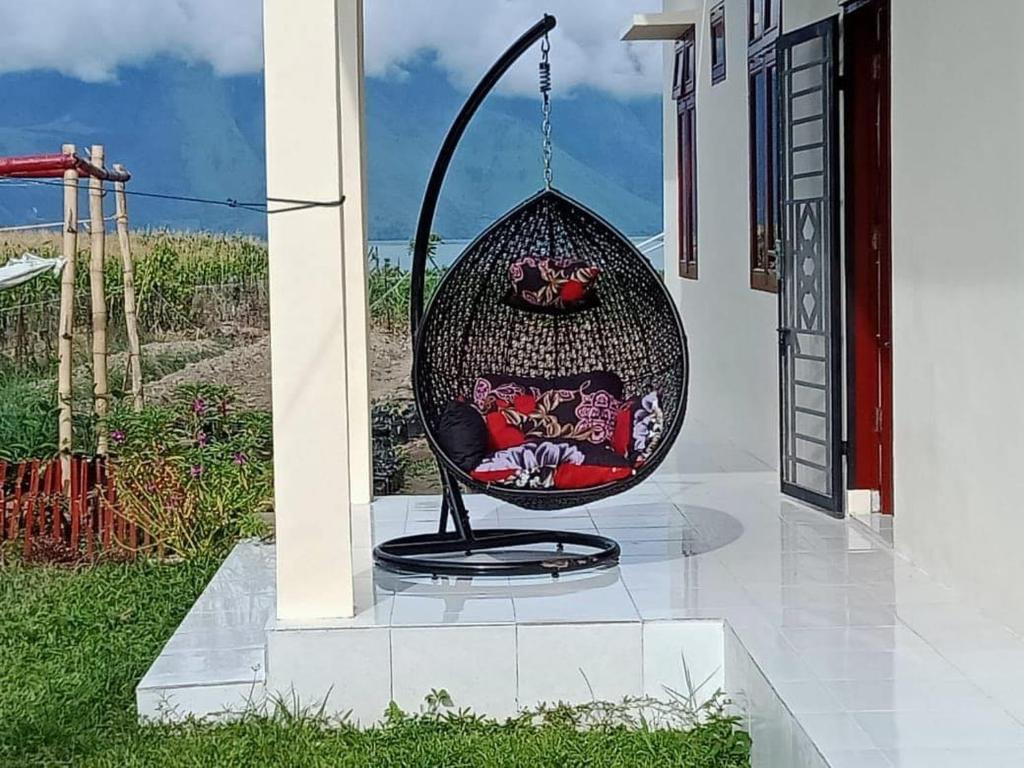 einen Schaukelstuhl auf der Seite eines Hauses in der Unterkunft Blesshomestay Samosir in Sinabono