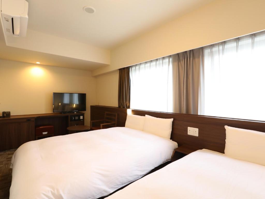 Postel nebo postele na pokoji v ubytování Dormy Inn Ikebukuro