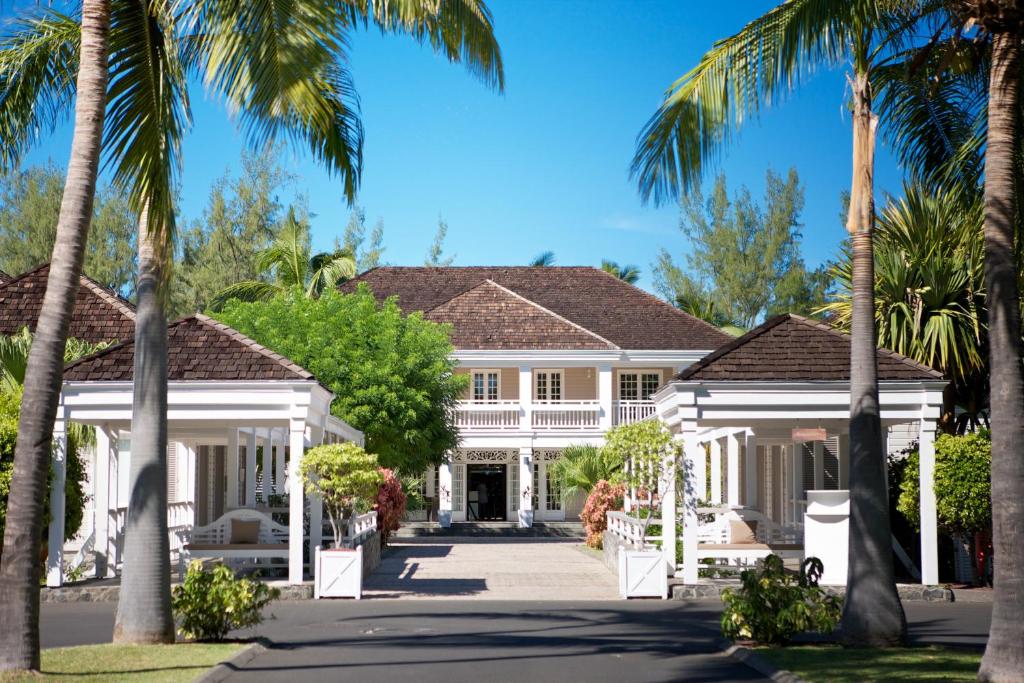 une maison avec des palmiers devant elle dans l'établissement LUX* Saint Gilles Resort, à Saint-Gilles les Bains