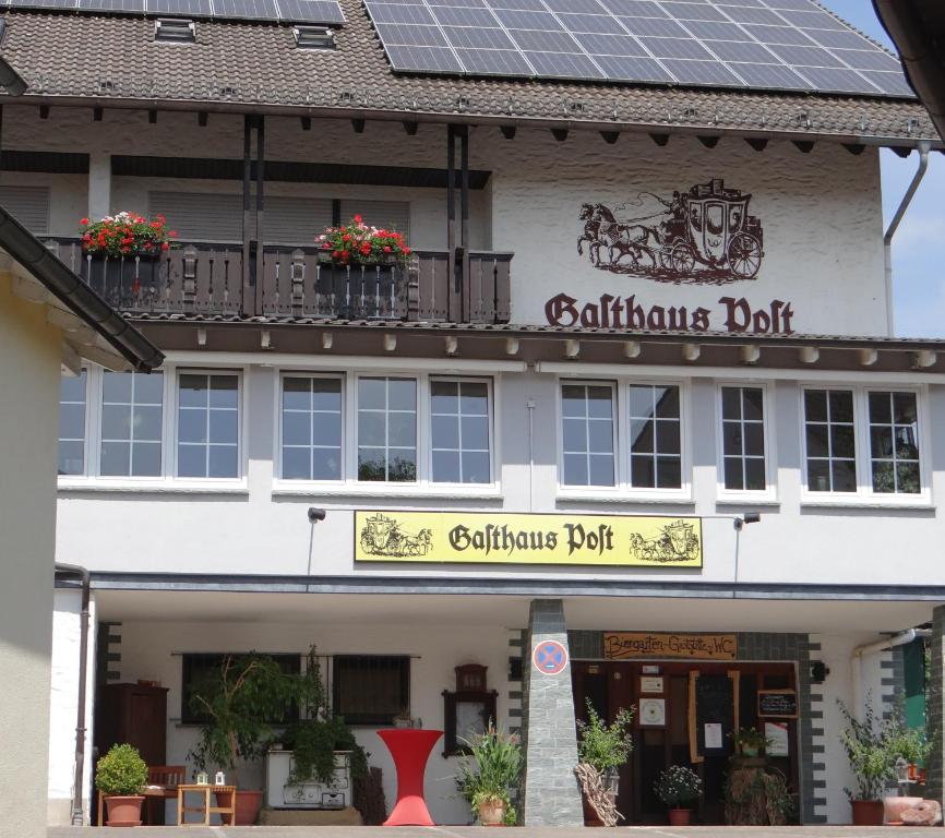 a building with a sign for a caulking district at Gasthaus Post in Goldbach