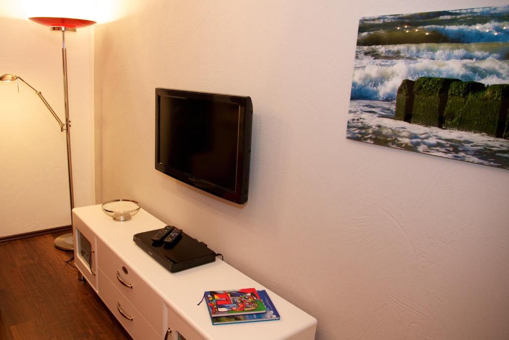 韋斯特蘭的住宿－Tag am Meer Sylt，客厅的墙上配有电视