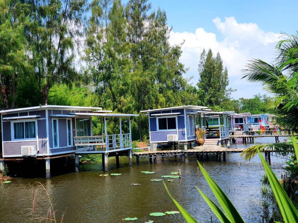 een rij huizen op een dok aan een rivier bij Phalagoon Resort in Ban Chang